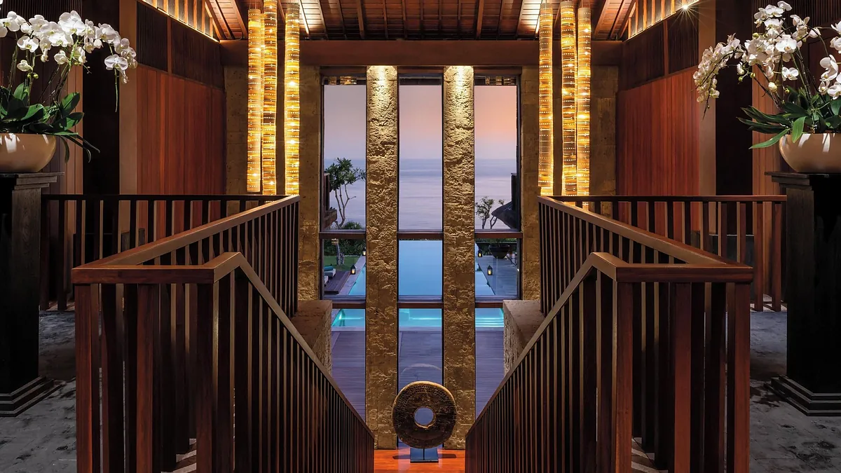 Grand mansion entrance staircase with orchids at dusk at Bvlgari Resort Bali