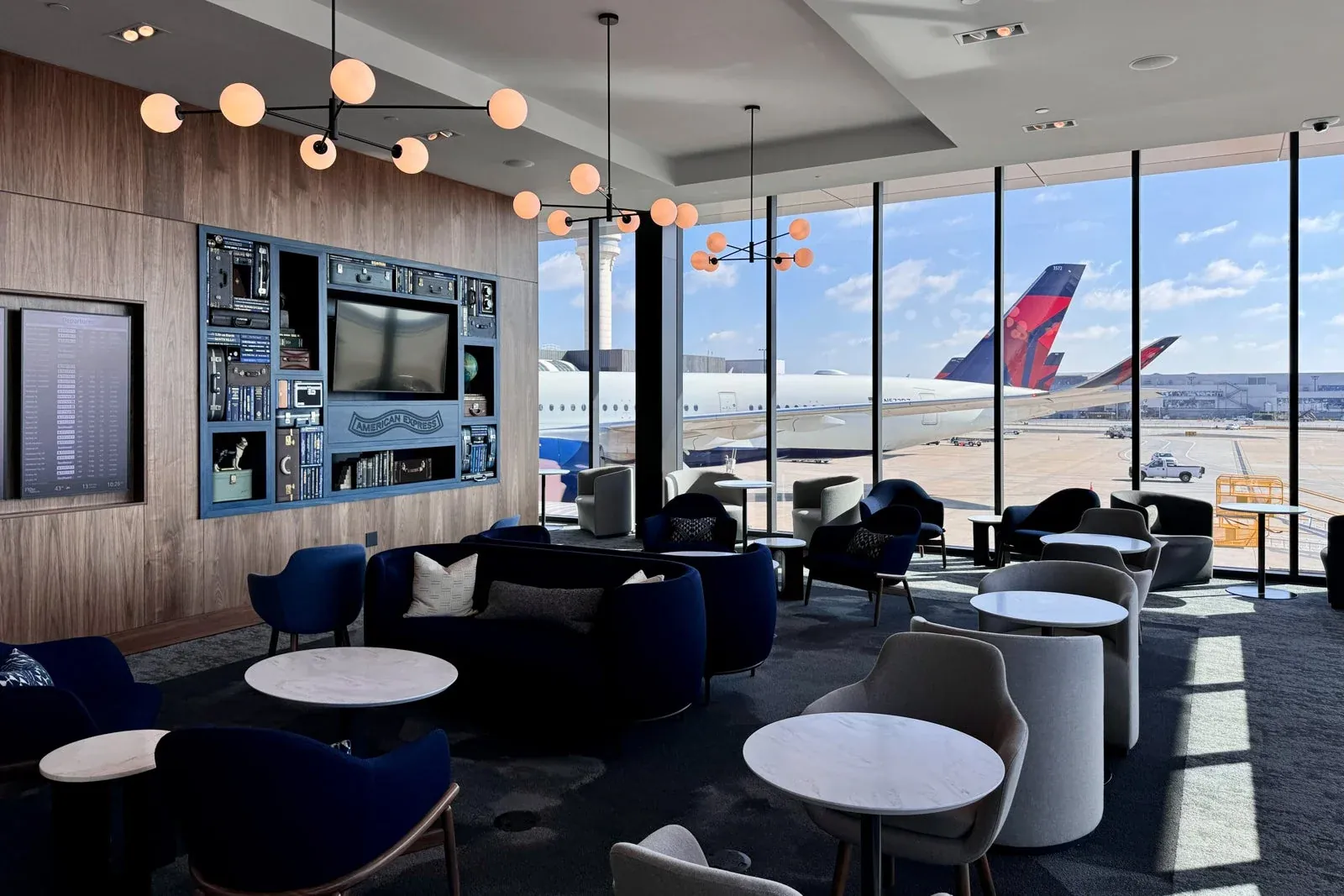 Inside an American Express Centurion Lounge with a bar, pendant lighting and buffet counter