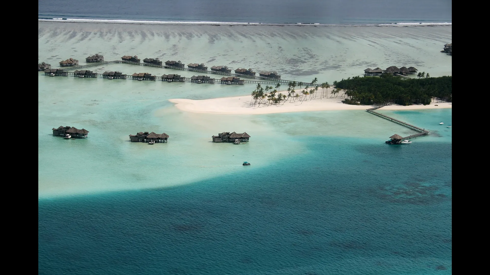 Affordable overwater villa over a turquoise Maldives lagoon under blue sky