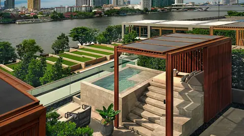 Terraced lawns and a long pool stepping down to the Chao Phraya with the city beyond