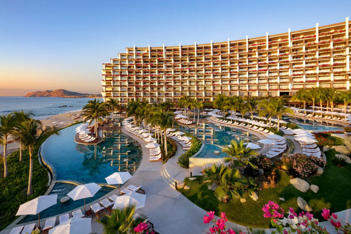 Tiered infinity pools ringed with loungers running down from a curved resort building