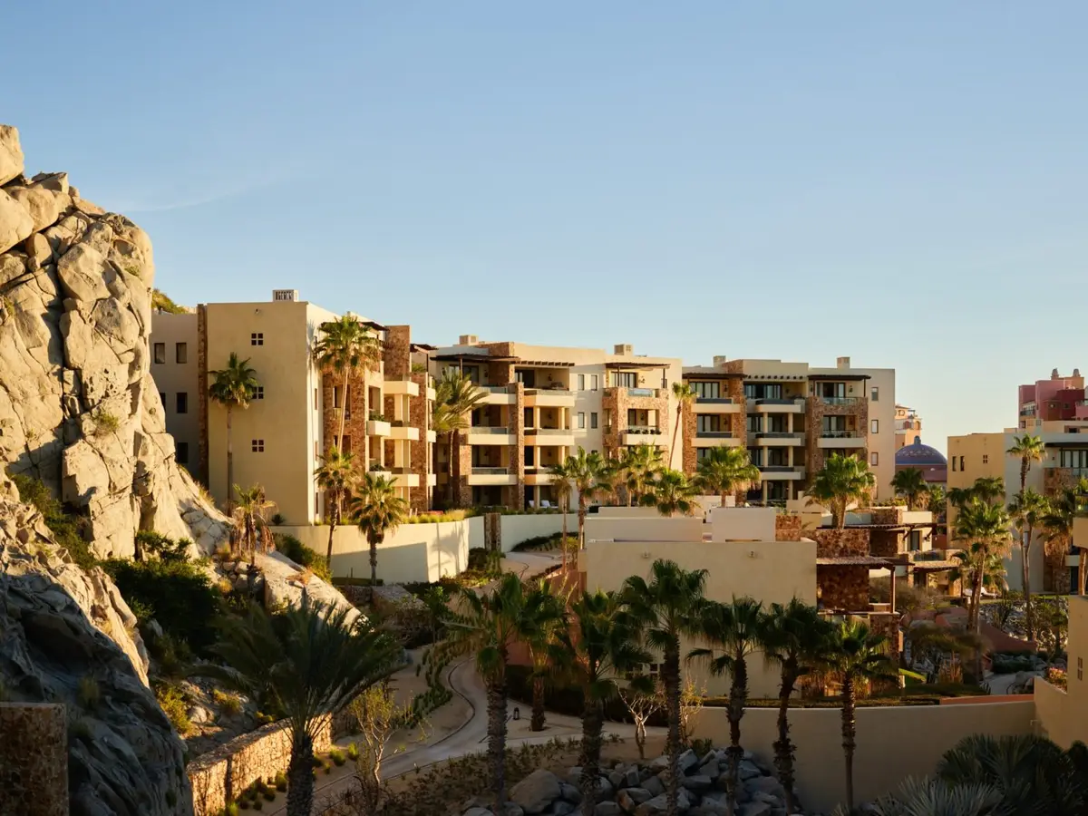 Sand coloured casitas climbing the rock above palm trees and the beach