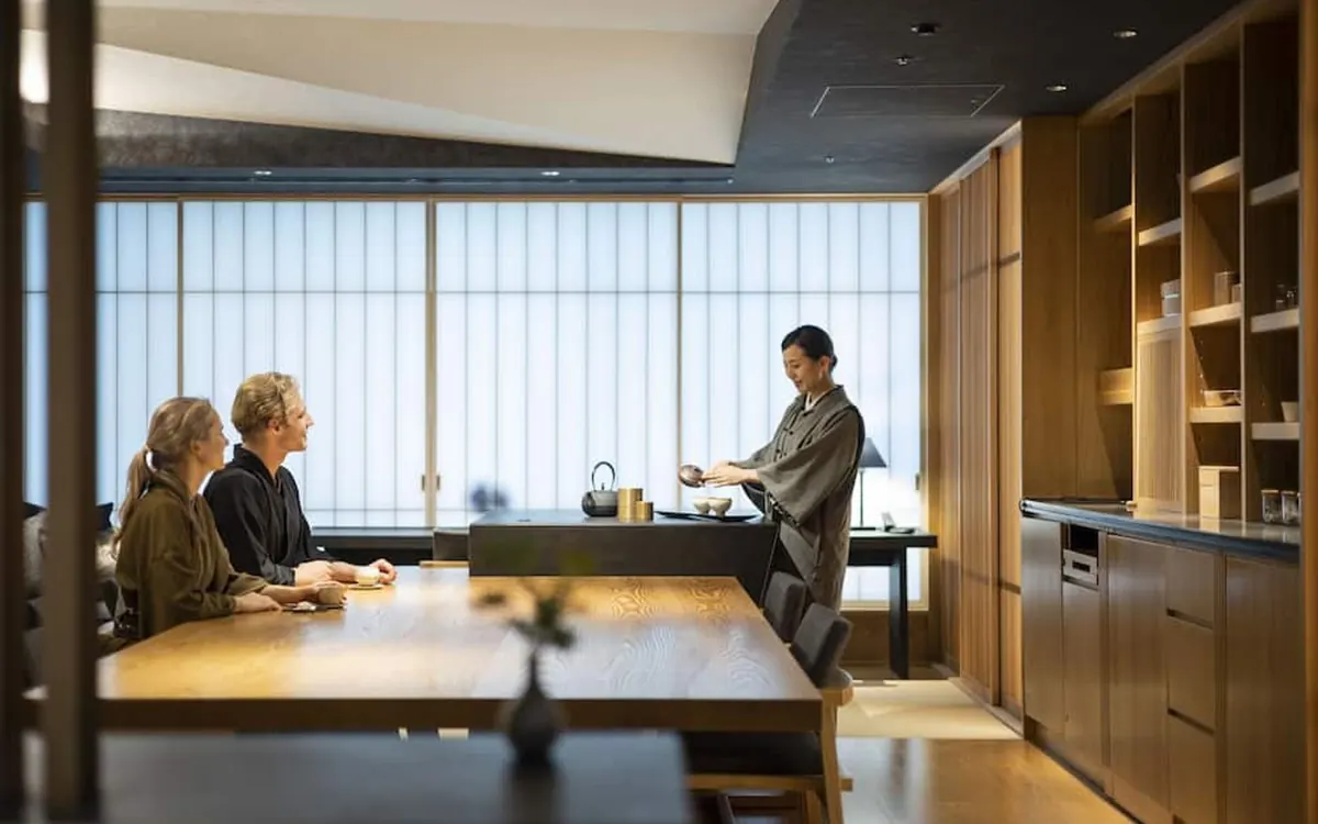 HOSHINOYA Tokyo, ochanoma lounge with staff serving tea beside shoji windows, Otemachi