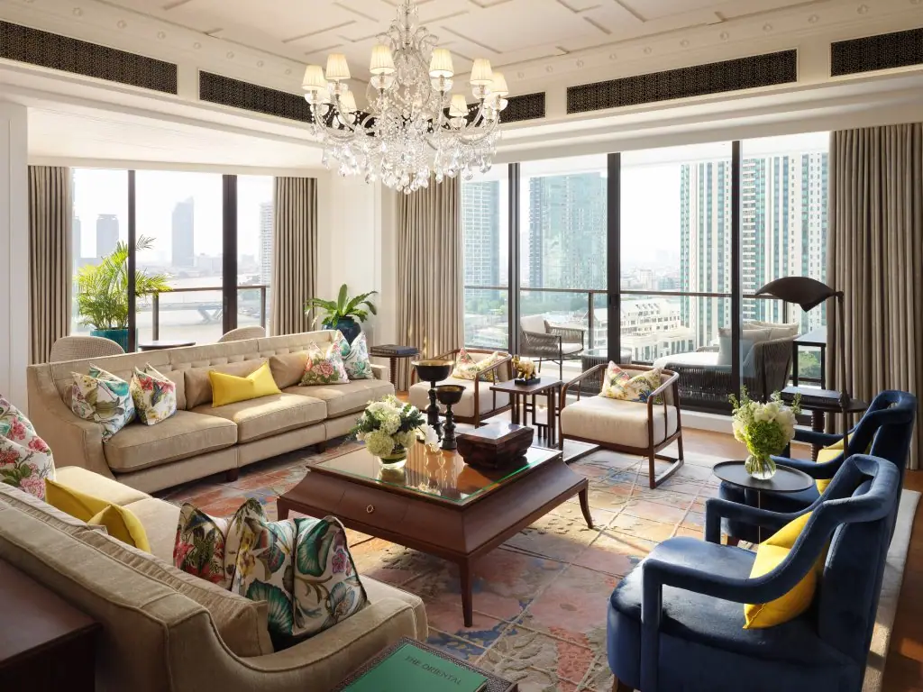 A suite sitting room with pale sofas and windows onto a wide brown river