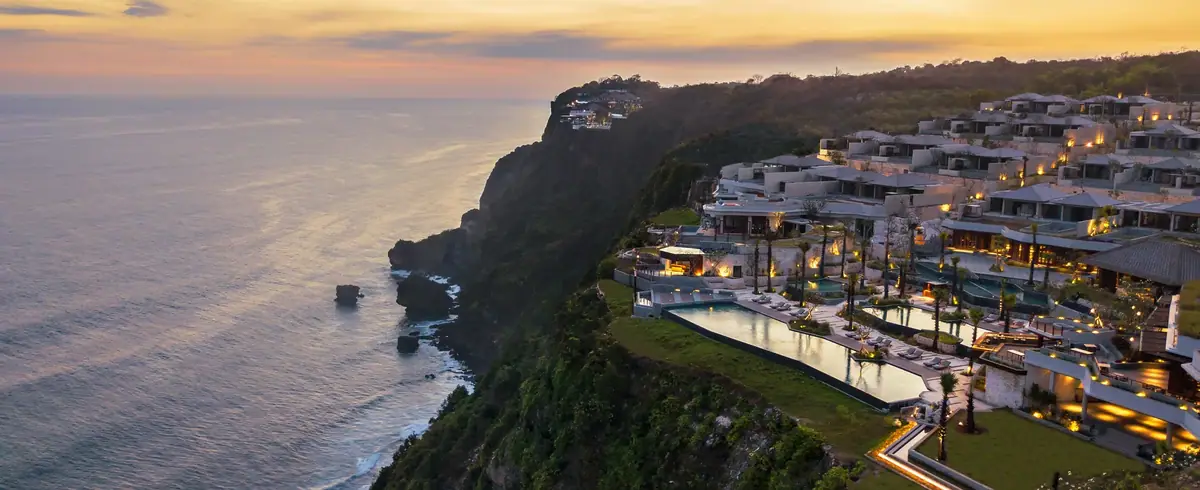 A clifftop resort of low buildings and pools above a dark sea