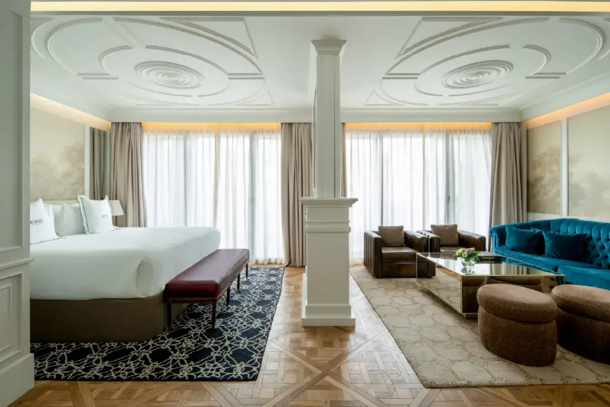 A suite at Bless Hotel Madrid with two beds, a plaster ceiling and a column