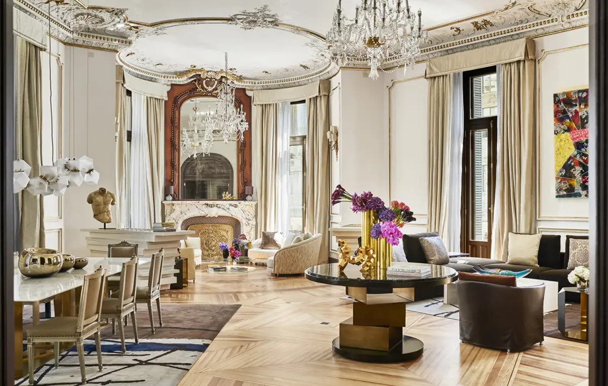 The living room of the Royal Suite at Four Seasons Hotel Madrid with a marble fireplace and chandeliers