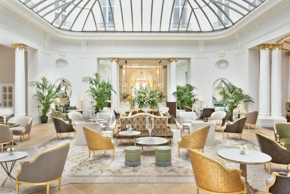 The glazed rotunda of the Palm Court at Mandarin Oriental Ritz Madrid with palms and wicker chairs