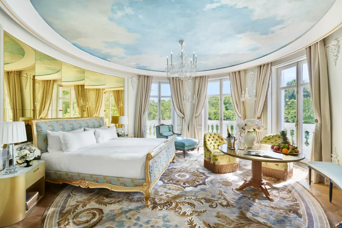 A suite at Mandarin Oriental Ritz Madrid with a painted sky ceiling above the bed
