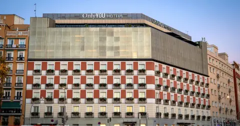 The chequered red and white facade of Only YOU Hotel Atocha seen from the street