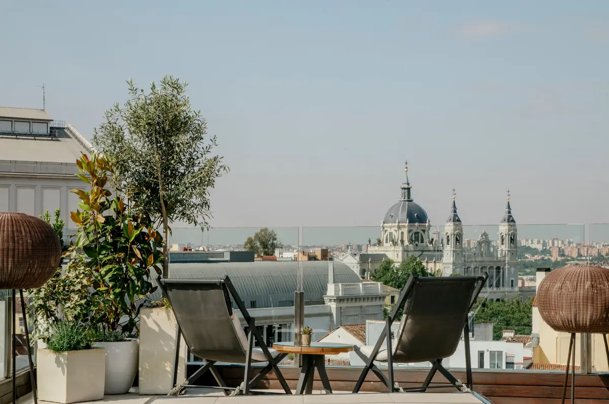 Two chairs on the roof terrace at Gran Melia Palacio de los Duques looking towards the Almudena Cathedral
