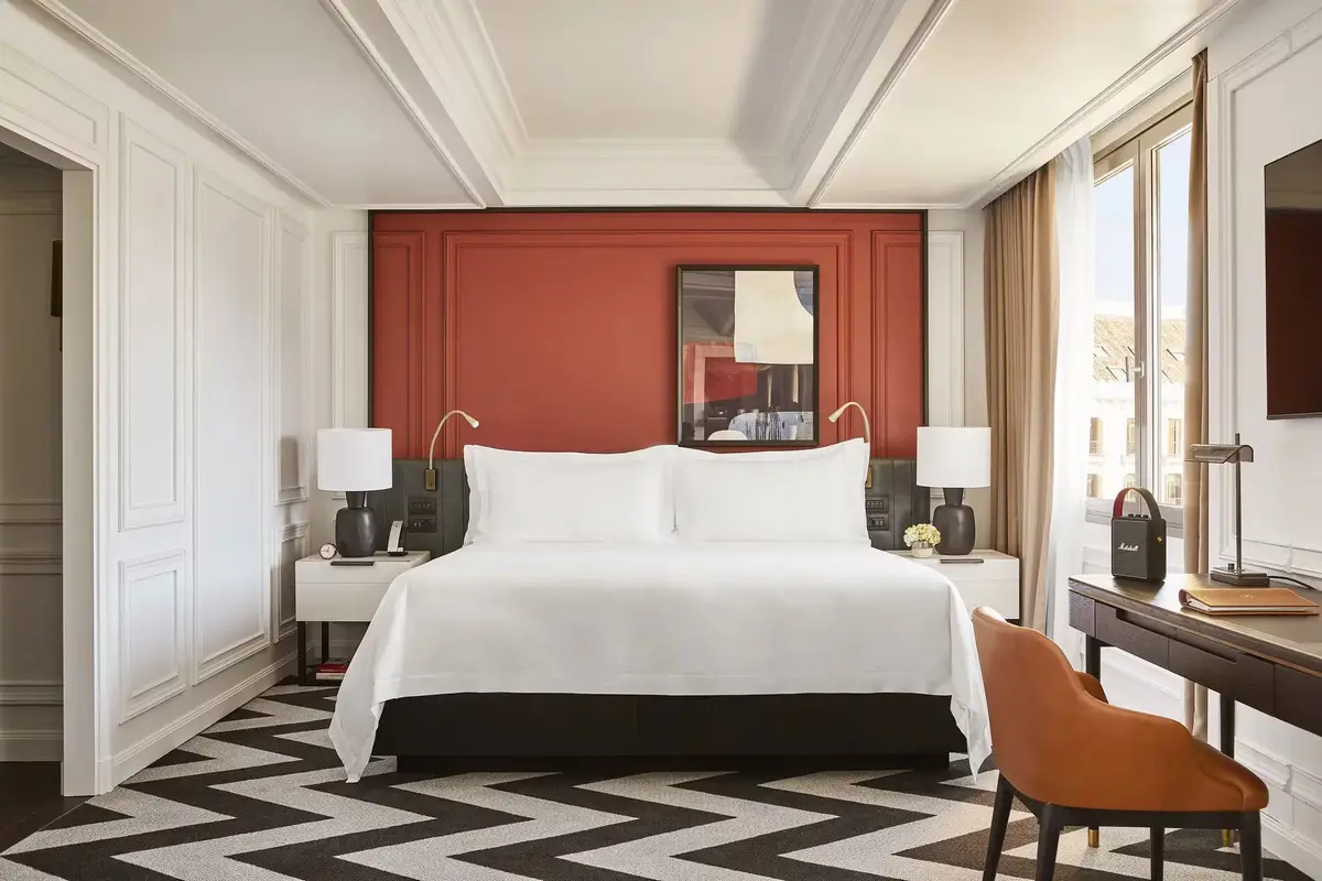 A Grand Premier room at Rosewood Villa Magna with a deep red panel behind the bed