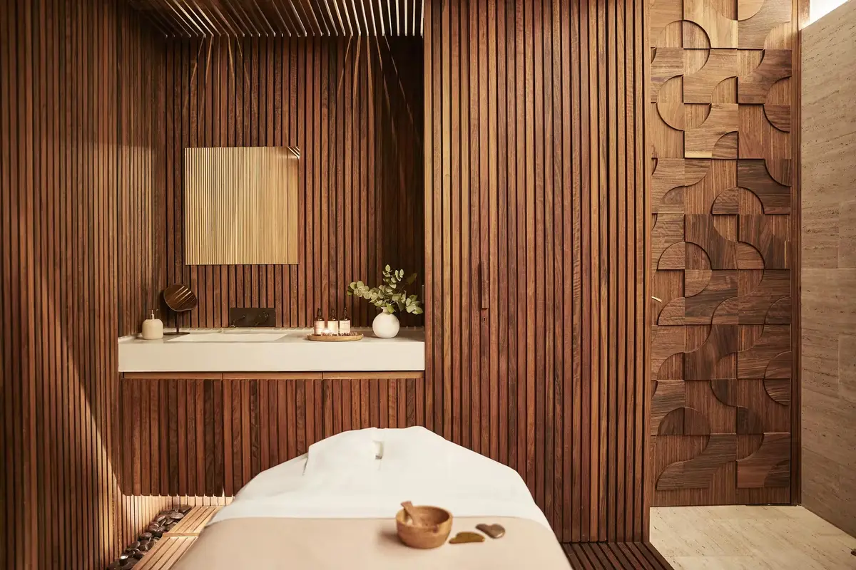 A treatment room at Sense spa in Rosewood Villa Magna with slatted walnut walls and a stone tub