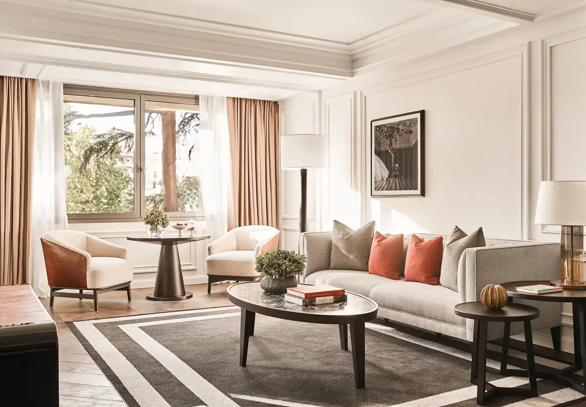 The living room of the Villa Magna Suite with a chevron floor and pale sofas