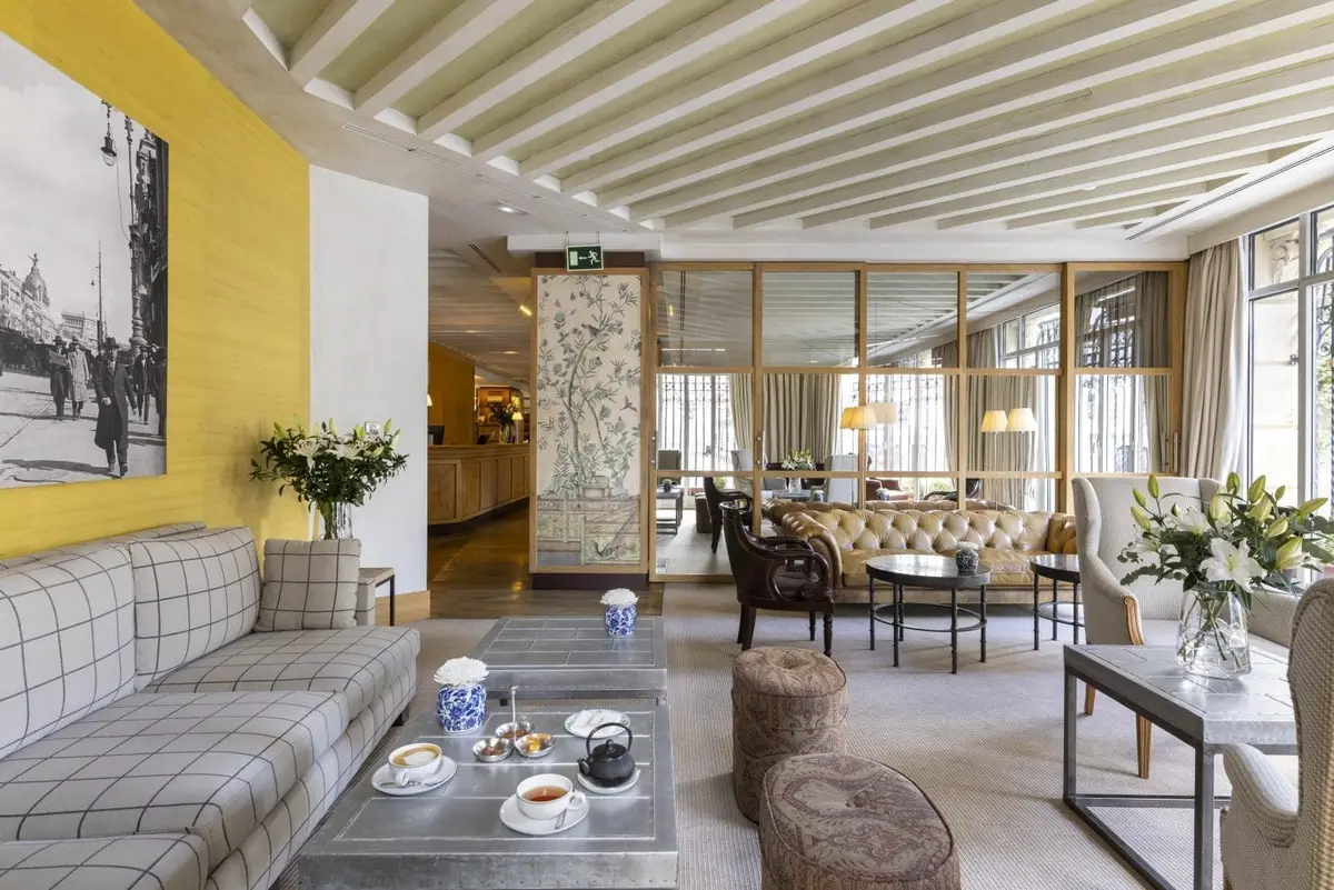 A lounge at URSO Hotel and Spa with a photographic mural of old Madrid and a long banquette