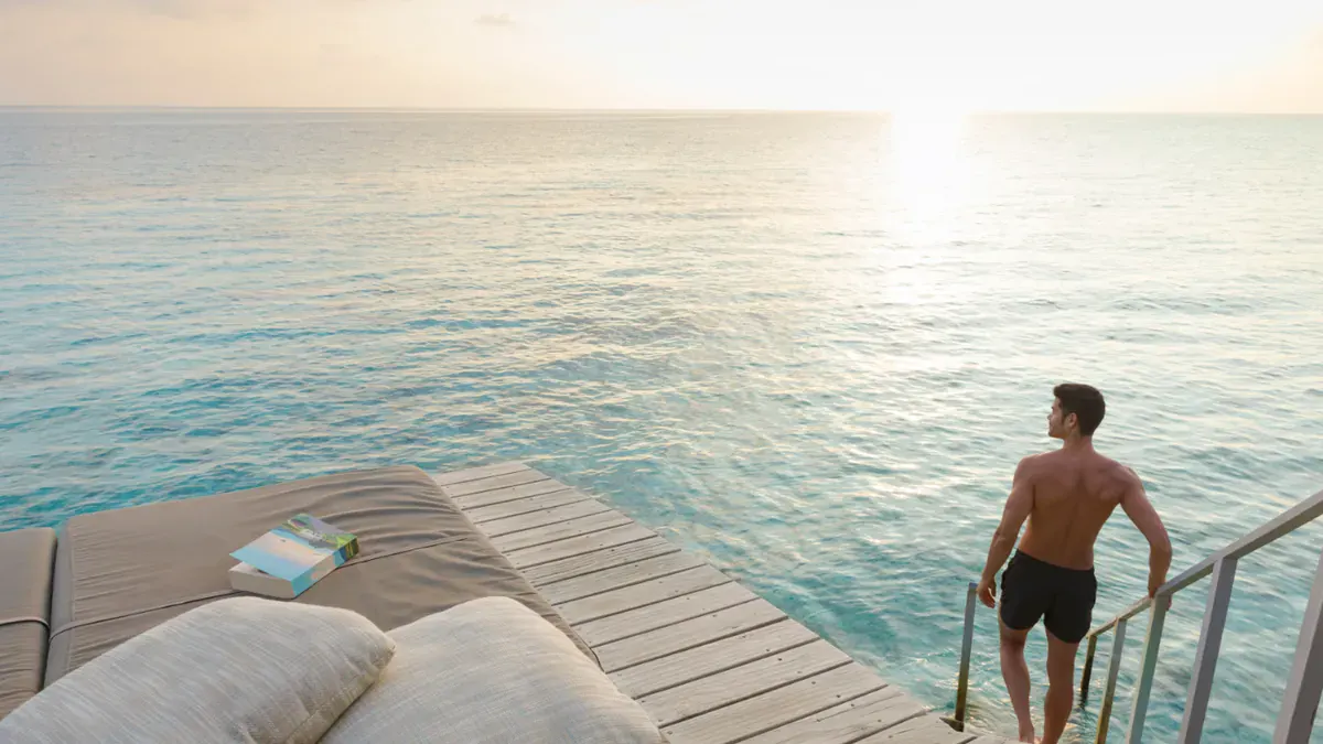 Steps from a water villa deck into the lagoon at Centara Ras Fushi