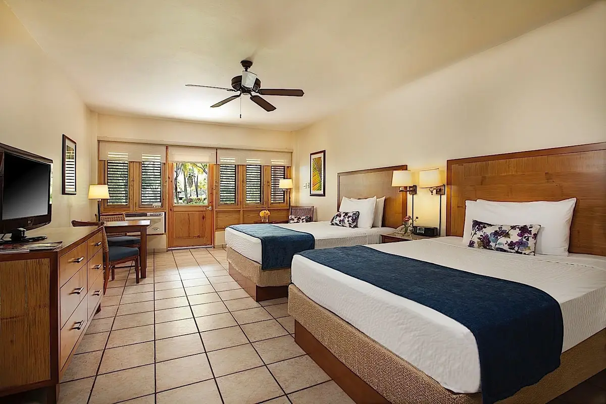Garden view room with two double beds, tiled floor and louvred shutters