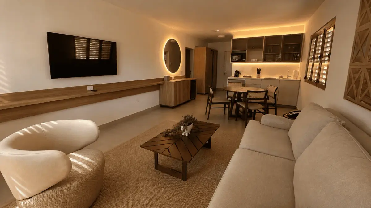 Villa living room with a long sofa, a dining table and a kitchen counter behind