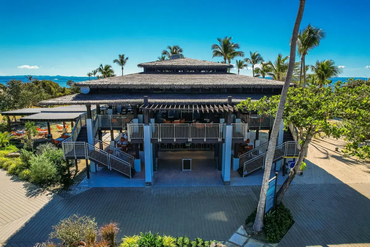 Thatched roof bar and grill beside wooden boardwalks on Palomino Island