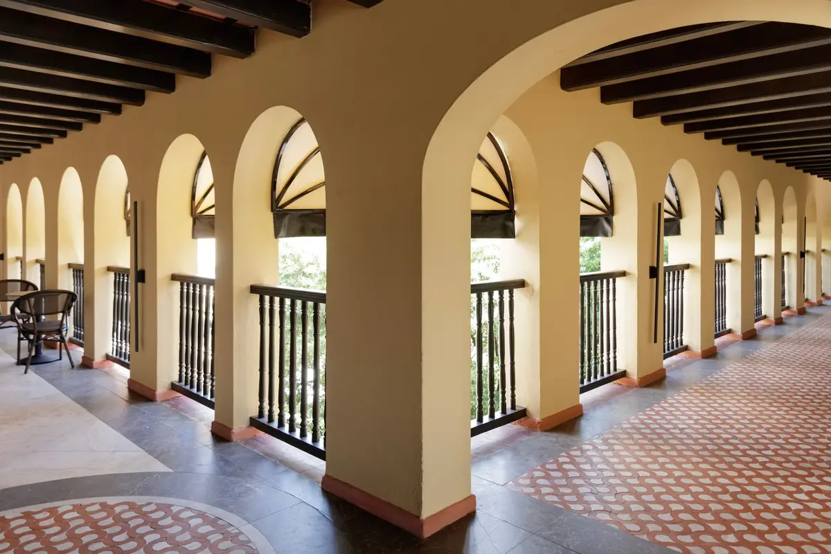 Long arcaded gallery with arched openings and a patterned tile floor