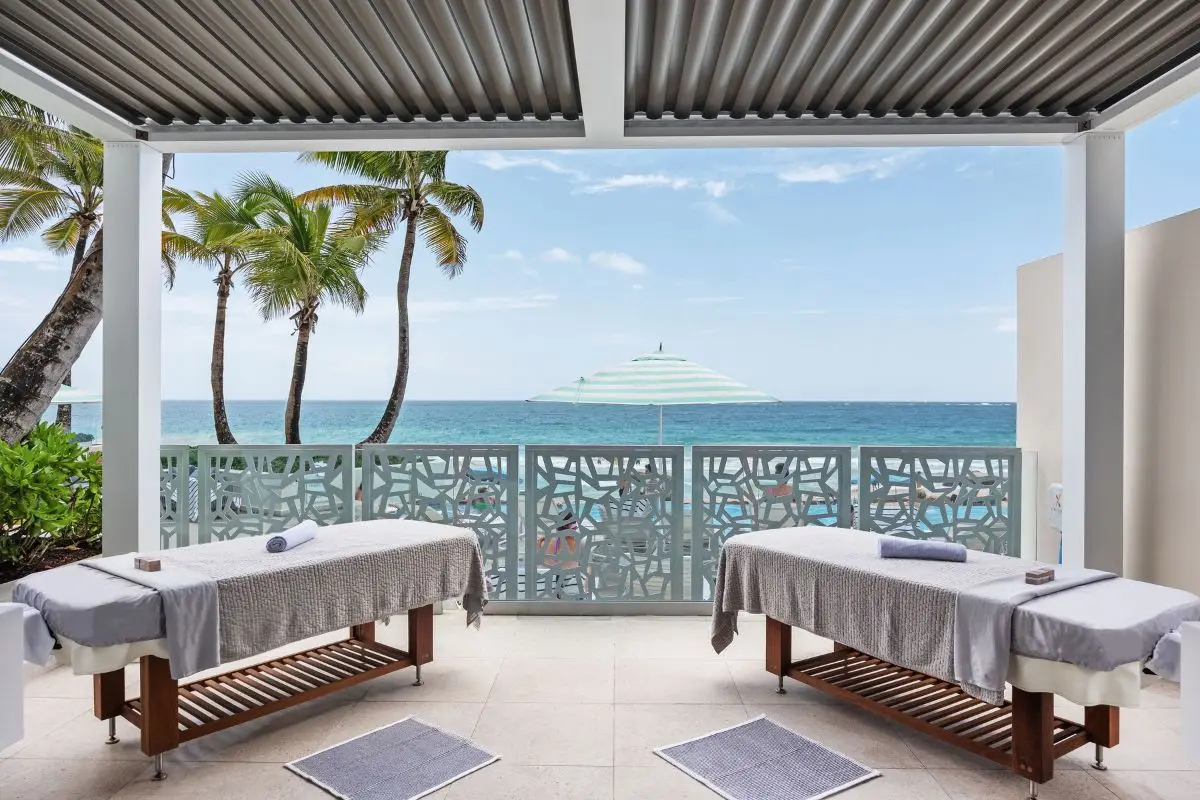 Two massage tables set up on an open terrace above the sea