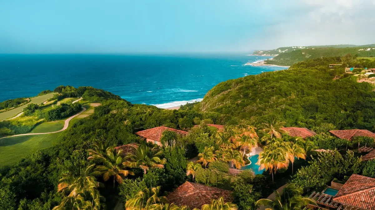 Casitas with terracotta roofs scattered across green headland above the Atlantic