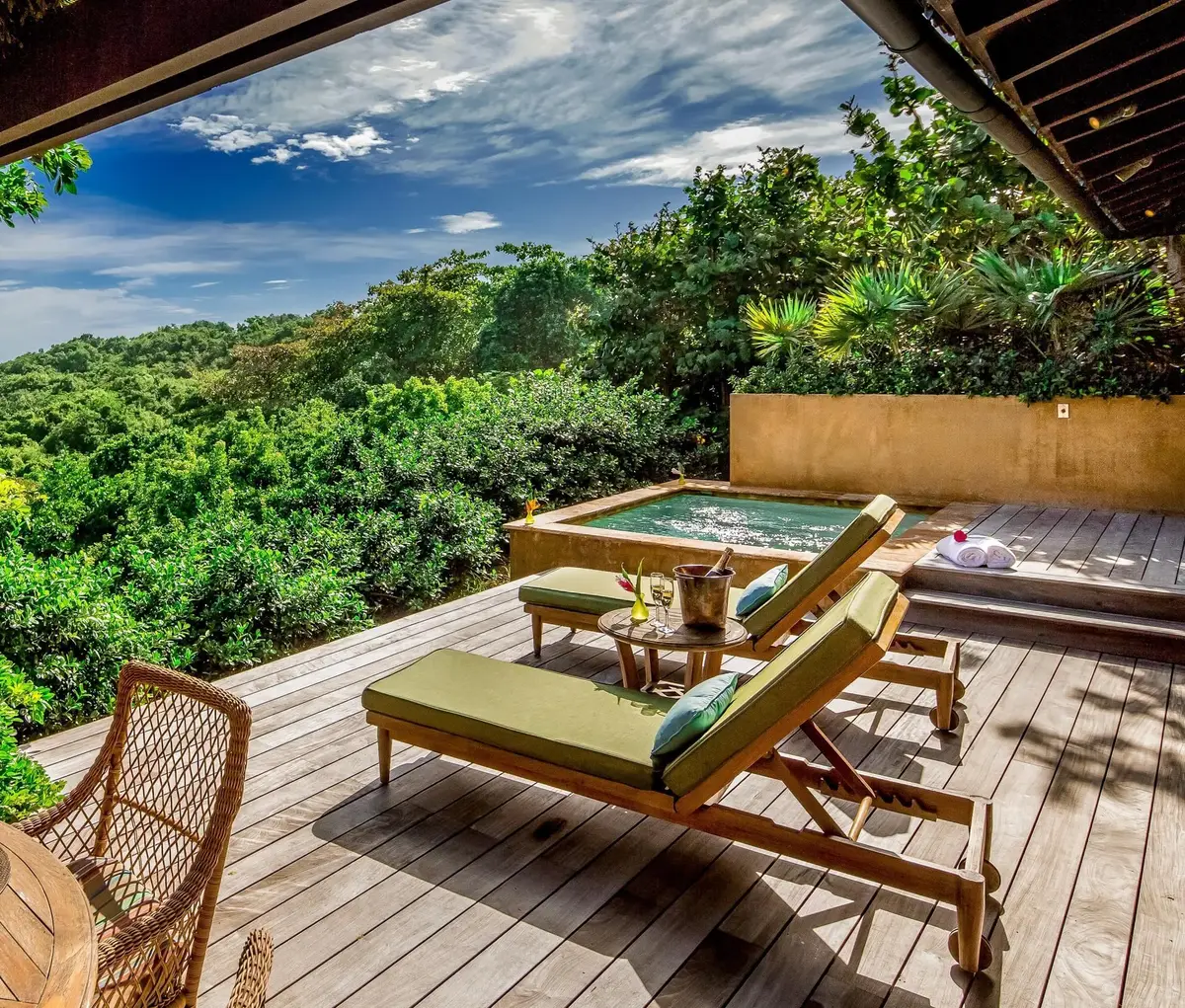 Timber deck with loungers and a small plunge pool set into the scrub above the coast