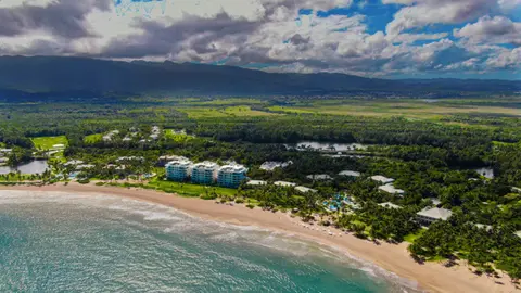 Aerial view of the resort buildings along the beach with the El Yunque mountains behind