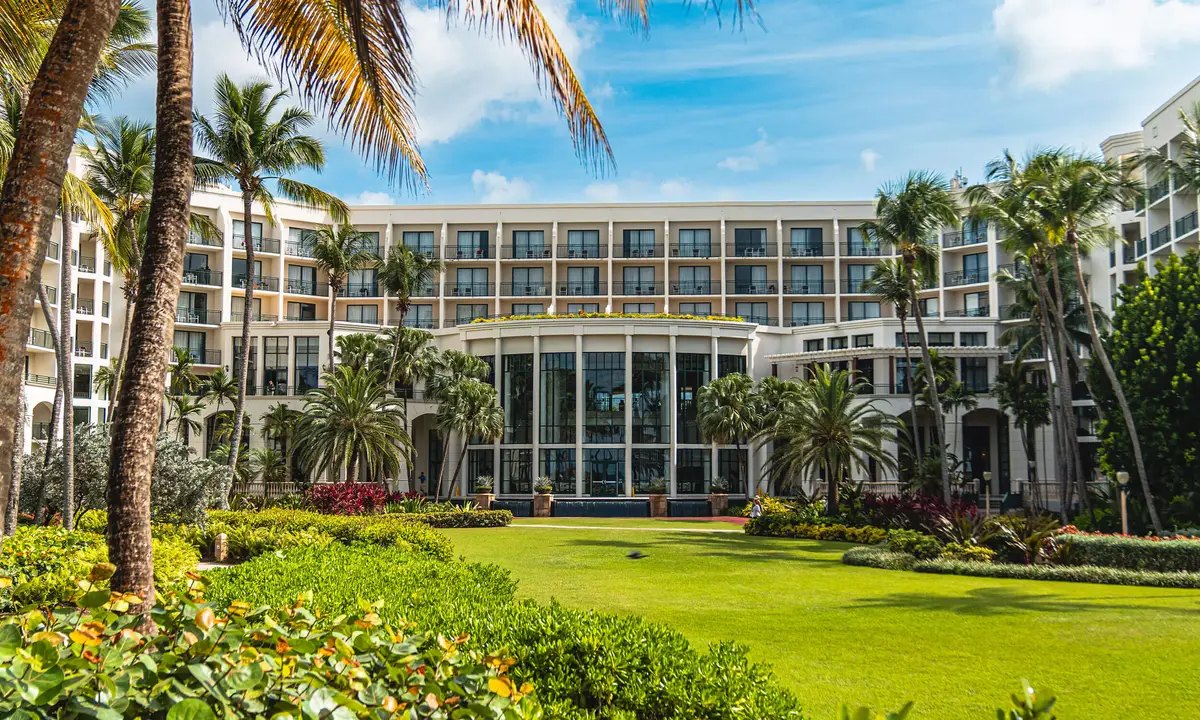 The long white main building seen across a lawn and flowerbeds