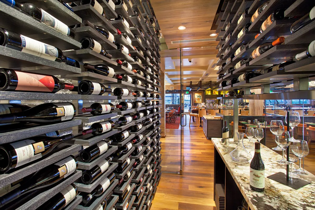 A restaurant with a floor to ceiling wine rack running the length of the room