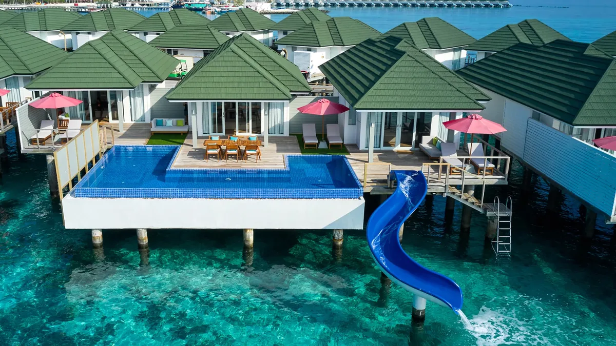 Siyam World overwater villa with a private slide and floating water park in Dhaalu Atoll