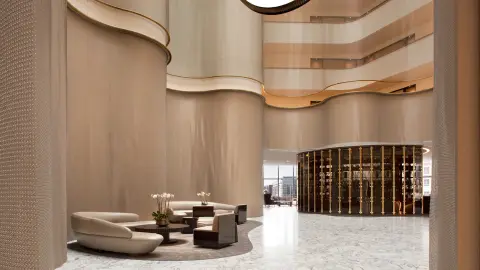 The curved timber walls of the Conrad Washington DC atrium above a terrazzo floor