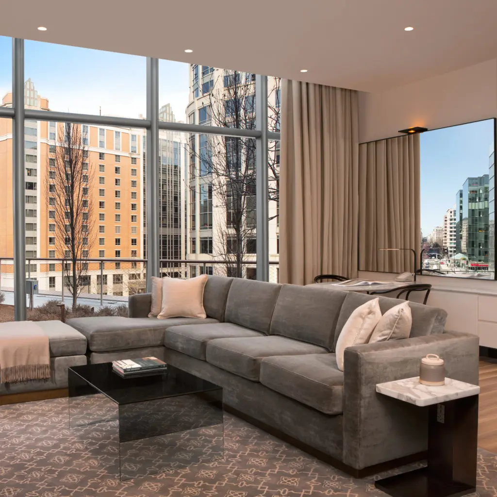 The living room of an avenue suite at the Conrad with a gas fire and a view over downtown