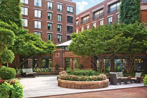 The planted courtyard at the Four Seasons Washington DC with the brick hotel behind it