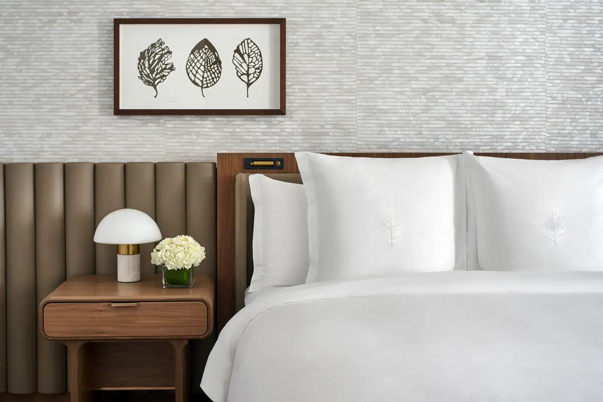 A guest bed at the Four Seasons Washington DC against a fluted leather headboard