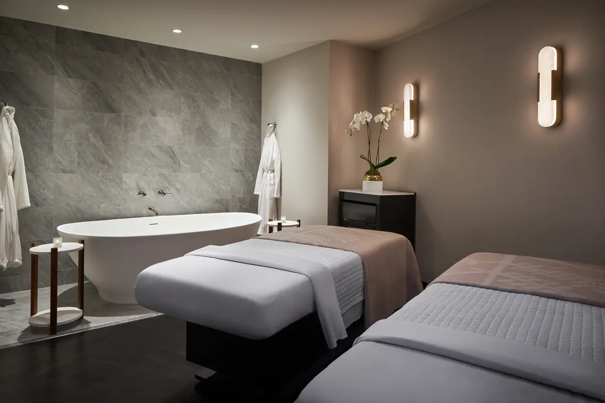 A double treatment room at the Four Seasons spa with a freestanding bath and two beds