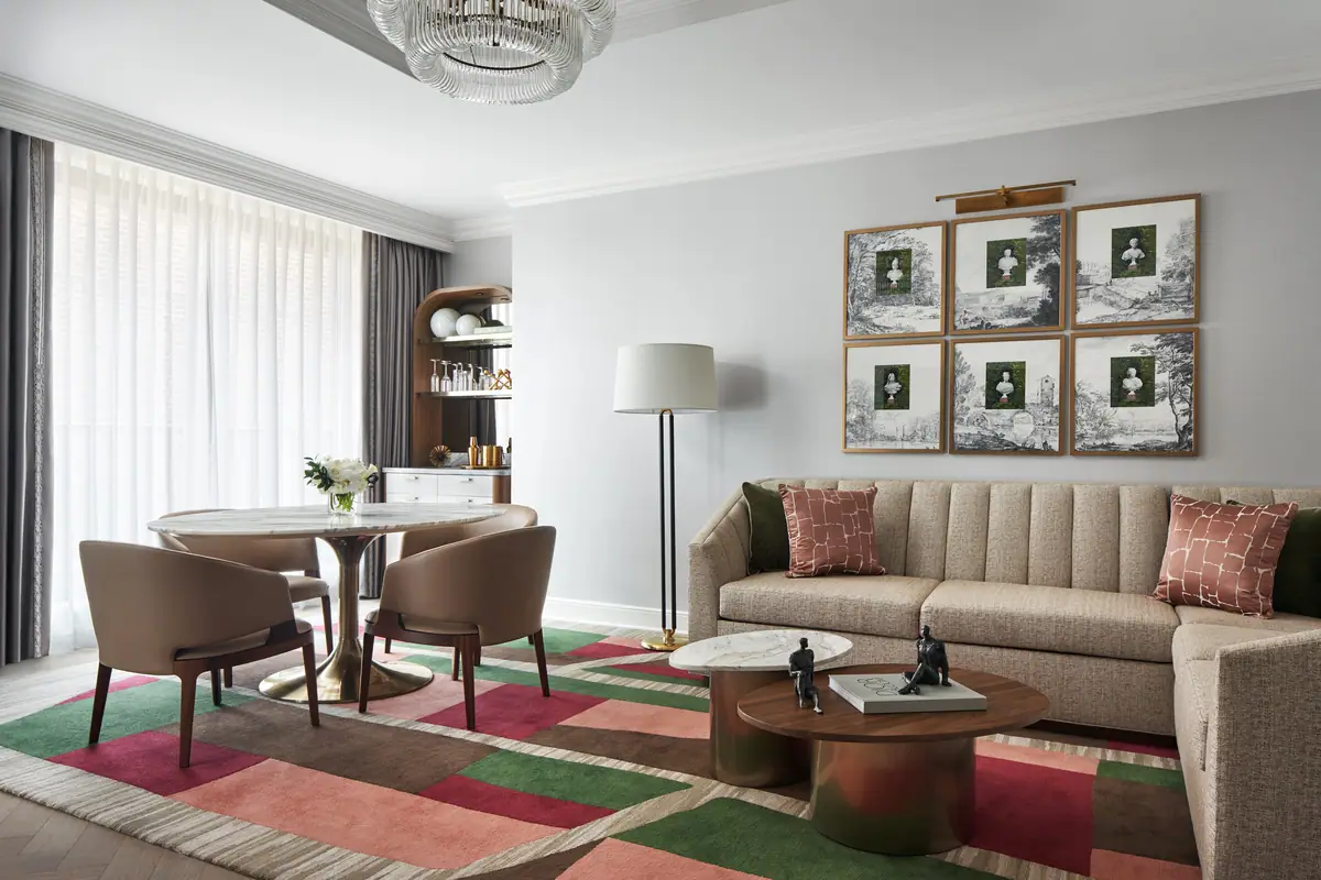 A suite sitting room at the Four Seasons Washington DC with a striped rug and framed prints