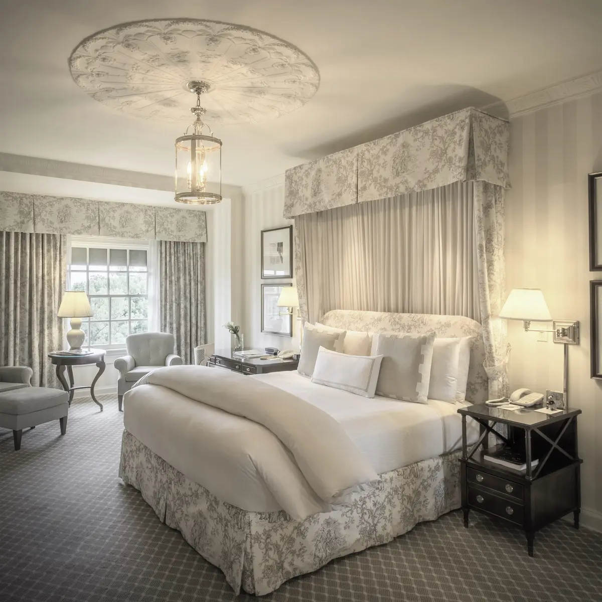 A premier king room at the Hay Adams with cream walls, toile curtains and a padded bench