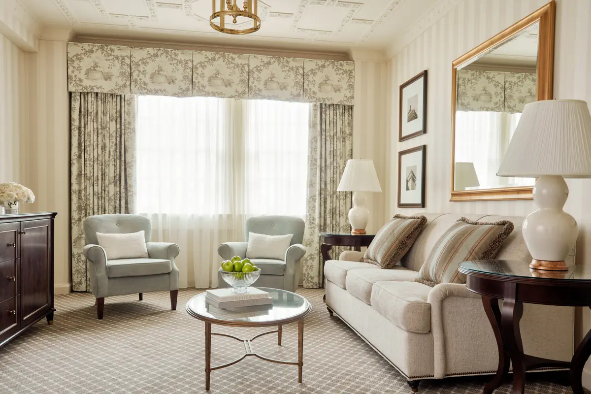 A suite sitting room at the Hay Adams with two armchairs, a sofa and a round table