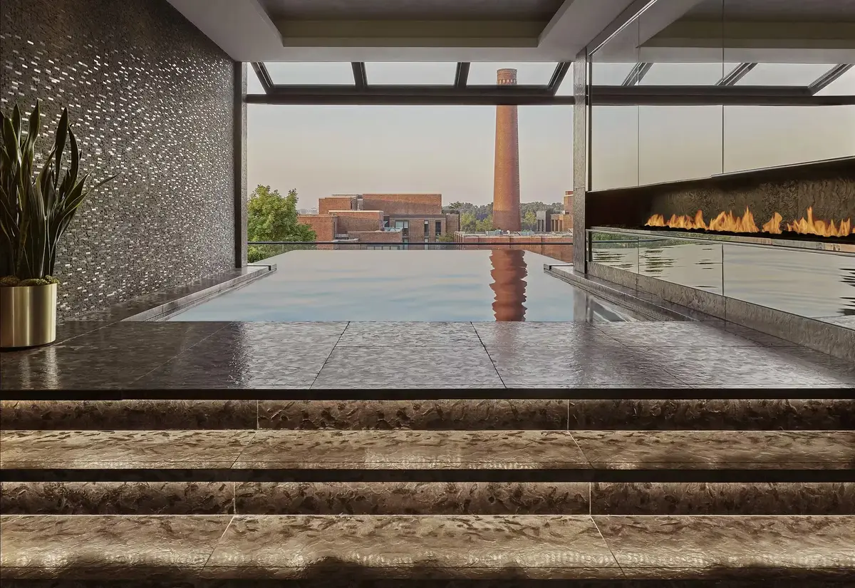 The rooftop pool at the Rosewood Washington DC with a fire feature along one side