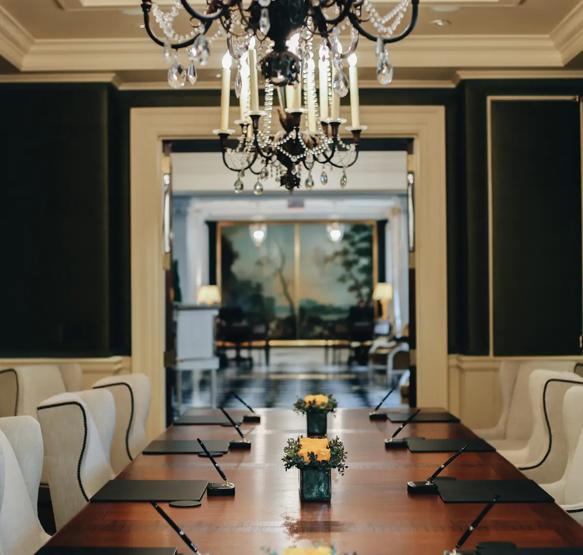 A panelled corridor at The Jefferson leading to a lounge with a chandelier