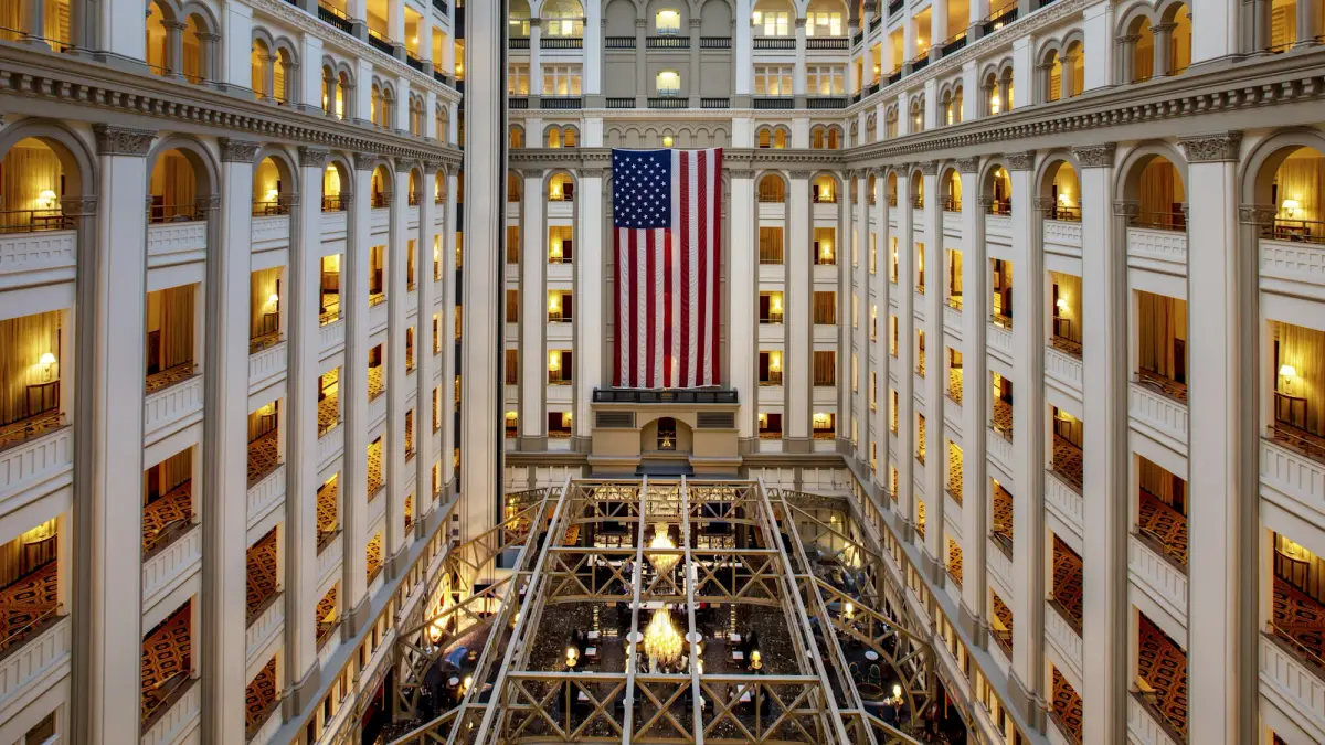 The nine storey glass roofed atrium at the Waldorf Astoria Washington DC with a large flag hung across it