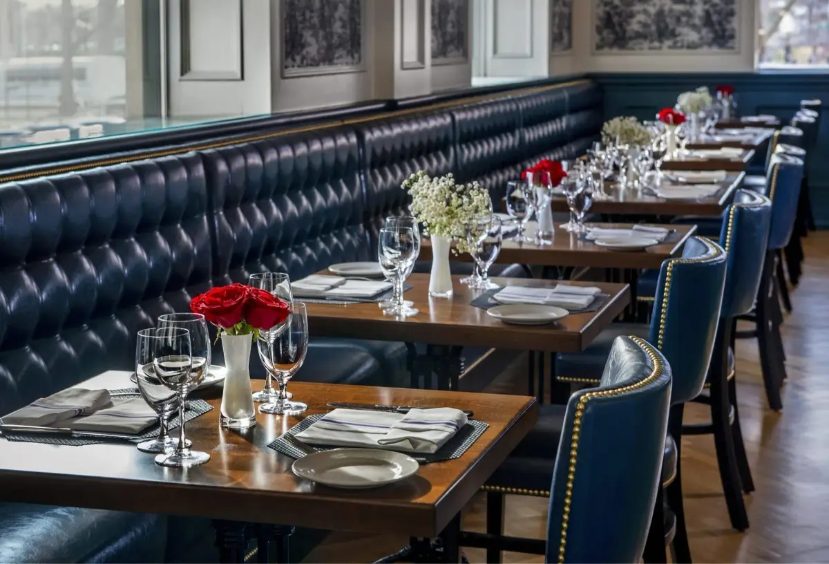 The interior of Café du Parc with leather banquettes and tables set for lunch