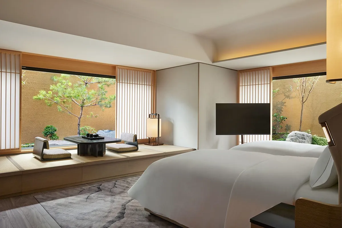 Dusit Thani Kyoto, a guest room bed beside its garden window, Kyoto