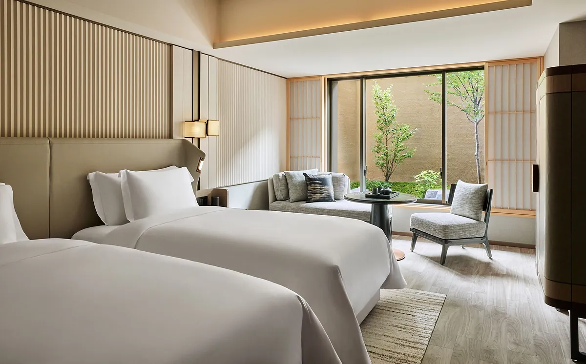 Dusit Thani Kyoto, twin beds and a chair facing the courtyard tree, Kyoto