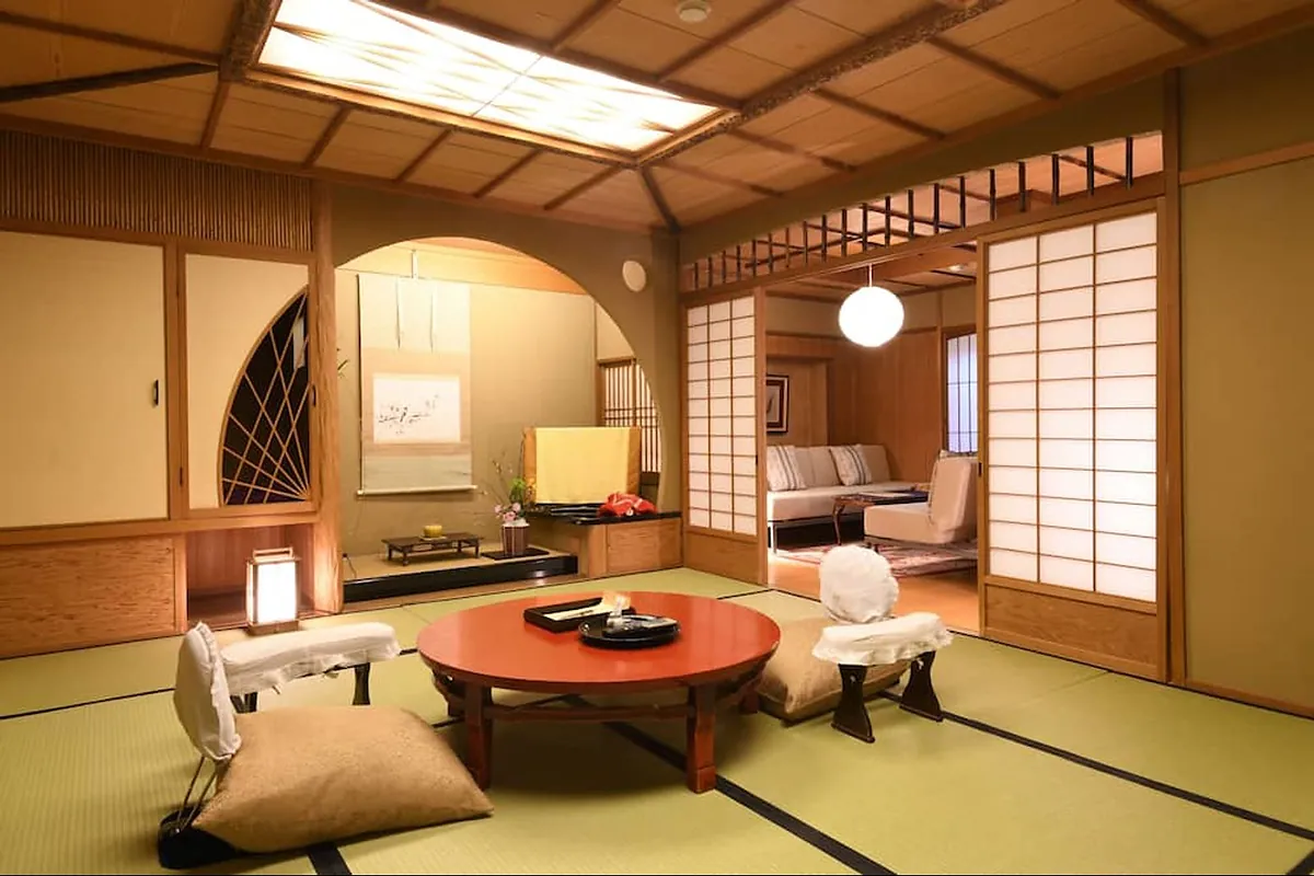 Seikoro Ryokan, a tatami sitting room with round table and arched window, Kyoto
