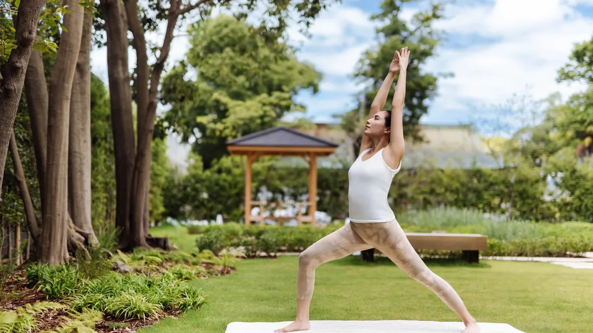 Six Senses Kyoto, a yoga pose in the garden beneath tall trees, Kyoto