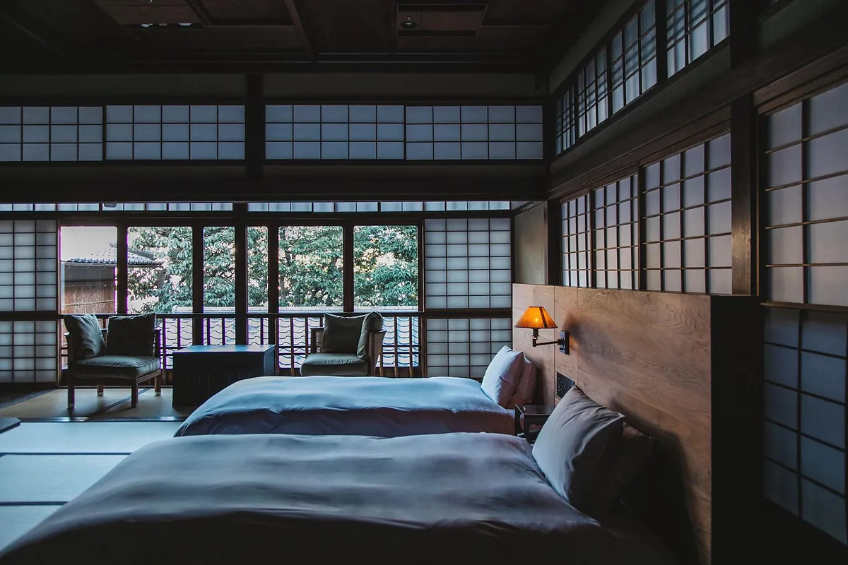 SOWAKA, a bed in an old tatami room behind shoji screens, Kyoto
