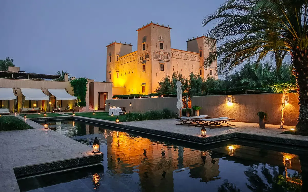 Dar Ahlam desert hotel Morocco with candlelit outdoor dining at dusk