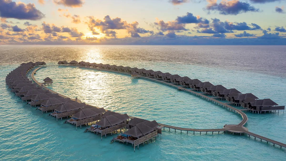 Overwater villas at sunset, Anantara Kihavah Maldives Villas